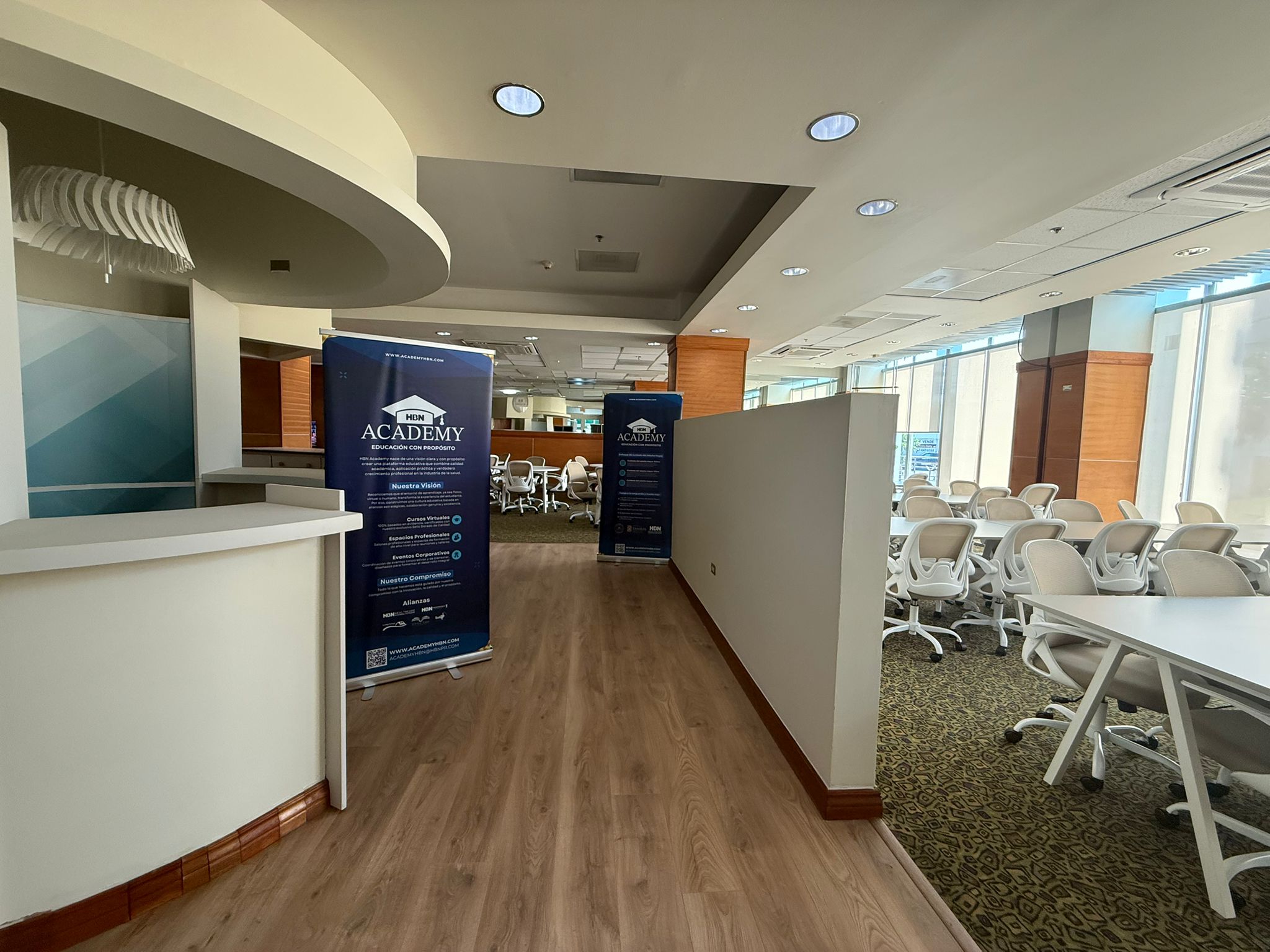 Area de recepcion con banners informativos de HBN Academy y salon de conferencias