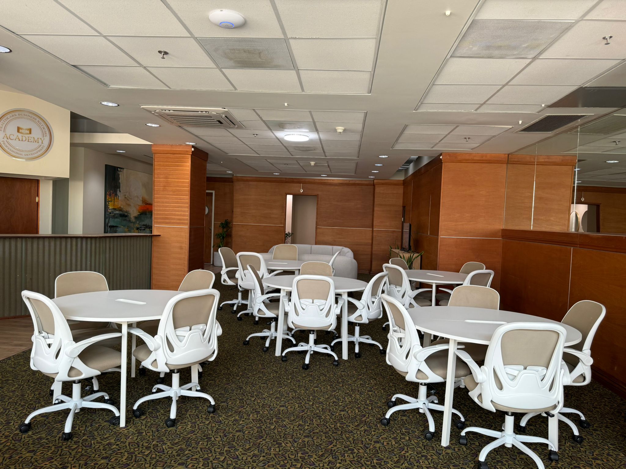 Sala de reuniones con mesas redondas y sillas ergonomicas para trabajo colaborativo